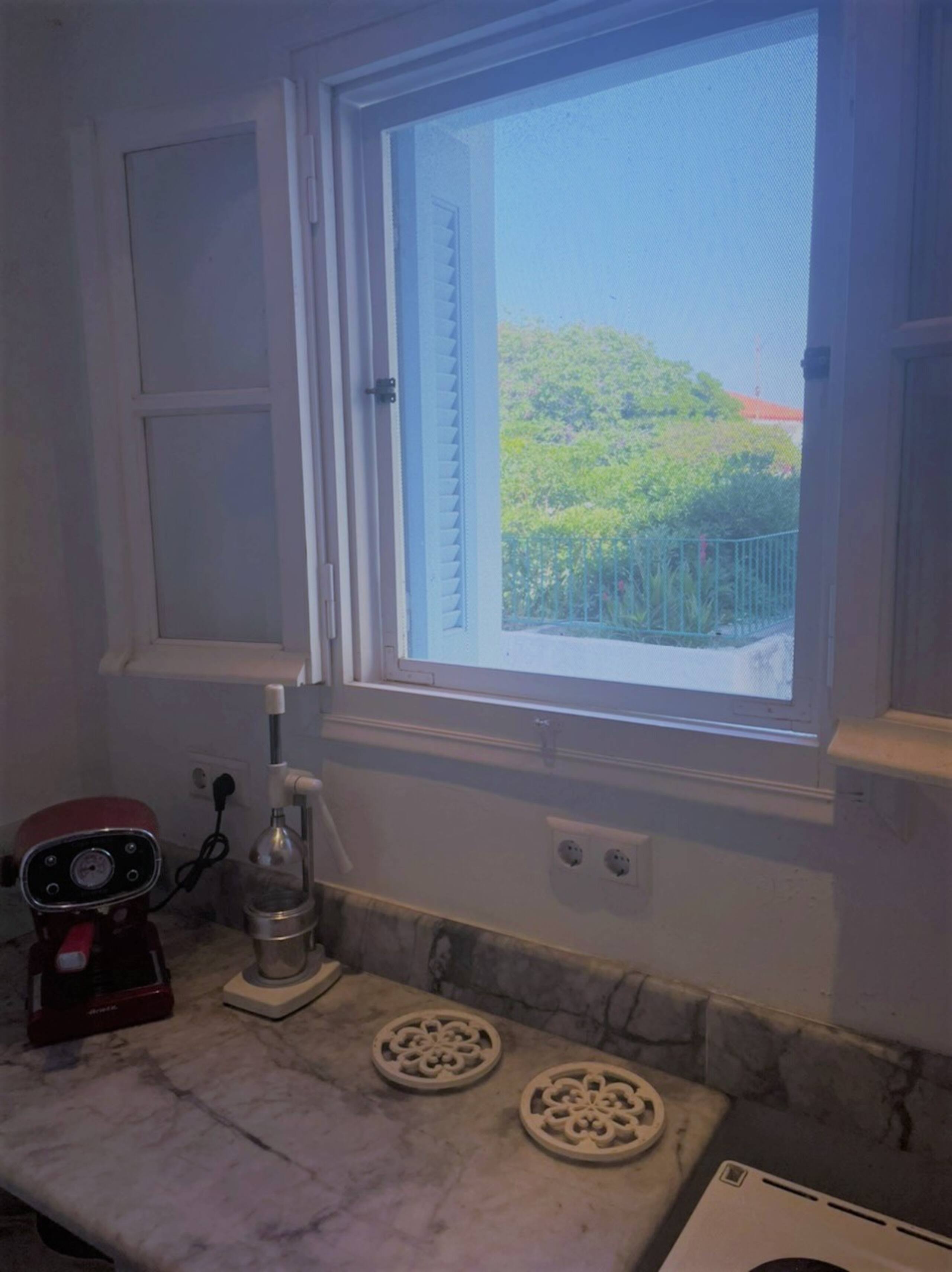 Kitchen window with garden and sea light beyond