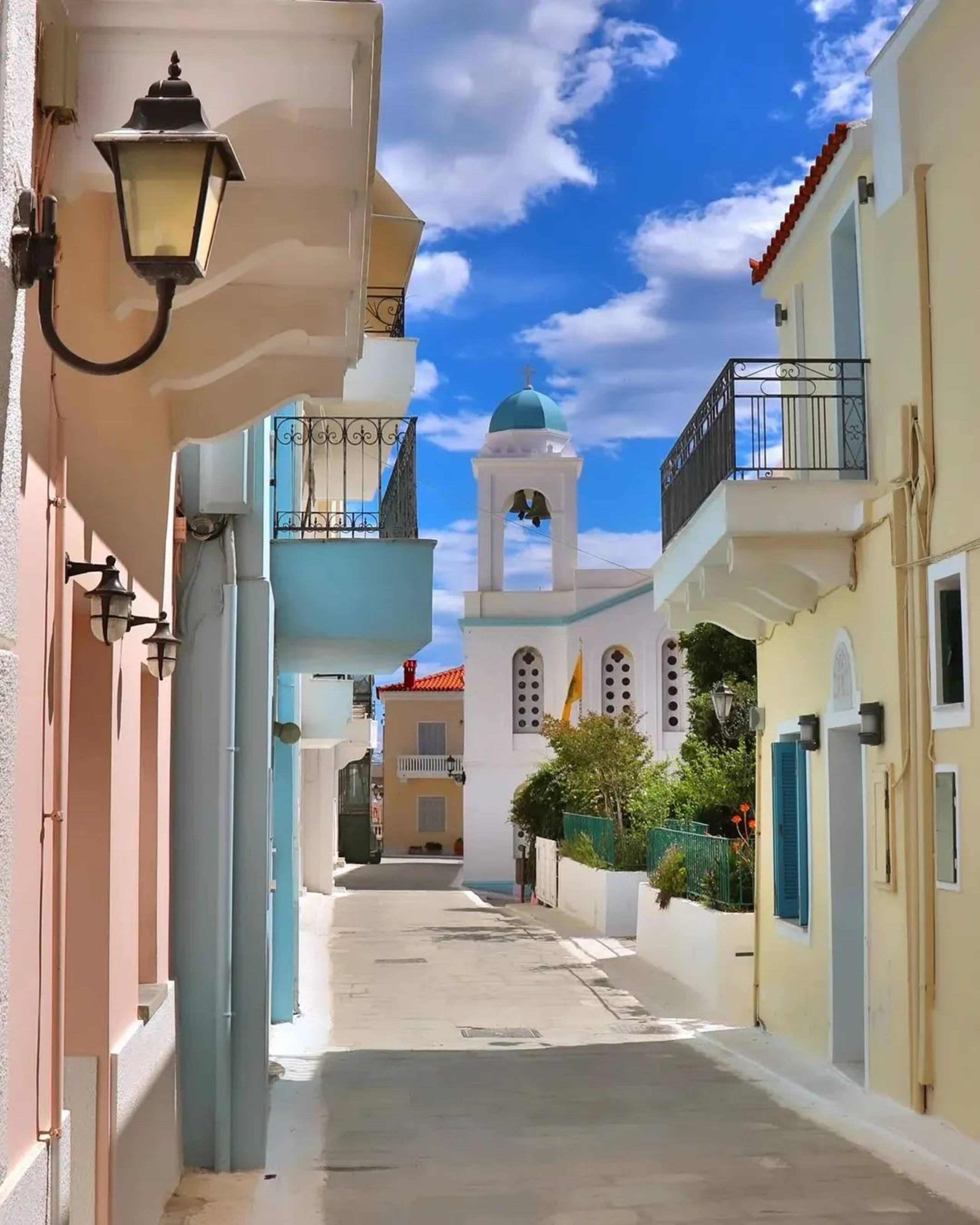 Village lane framed by pastel homes and church dome